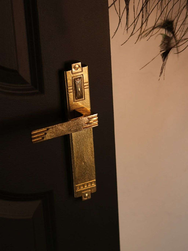 A front view of a natural brass finish passage door lever set
