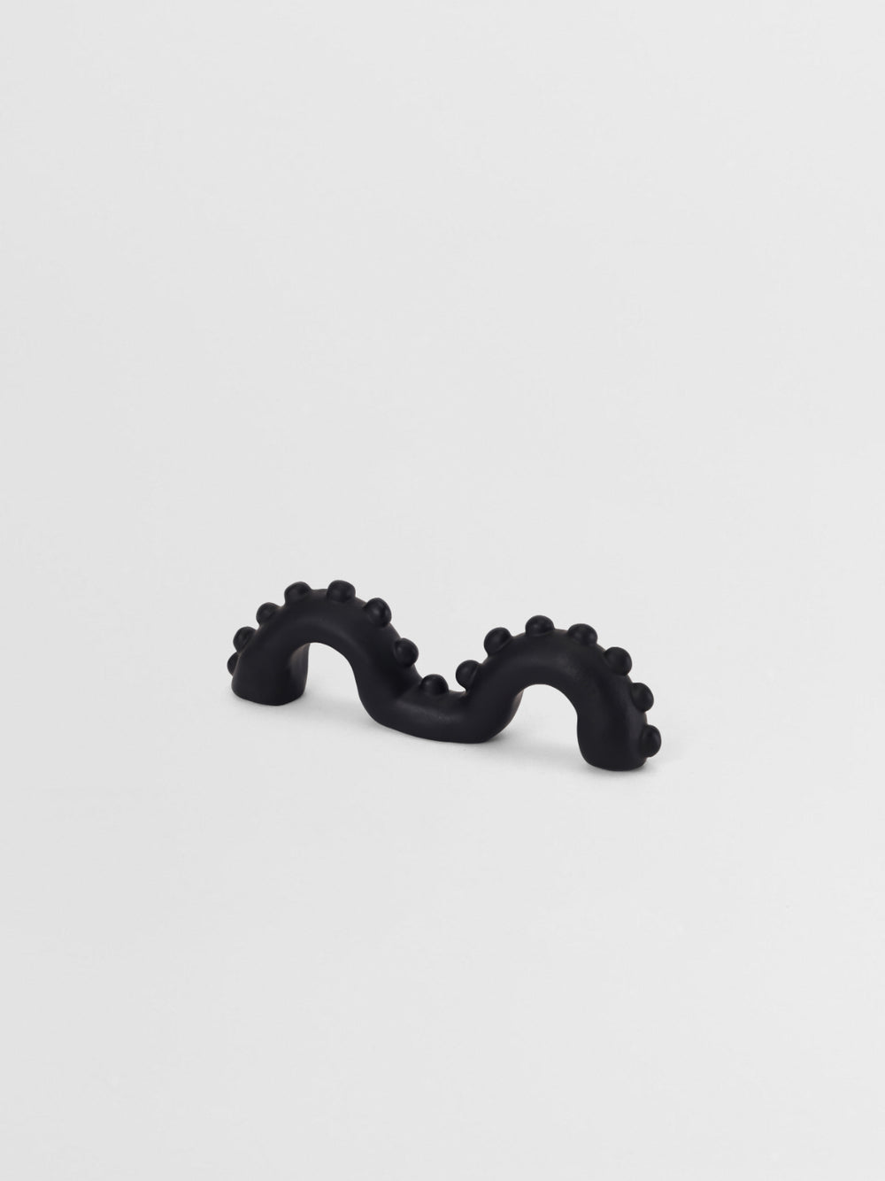 Black organic shaped pull on a light gray background