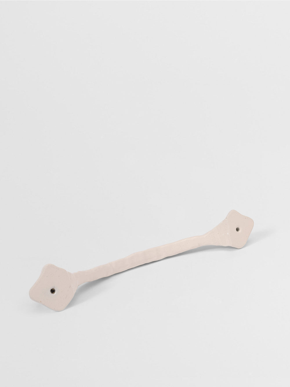 White organic cabinet handle on a light gray background