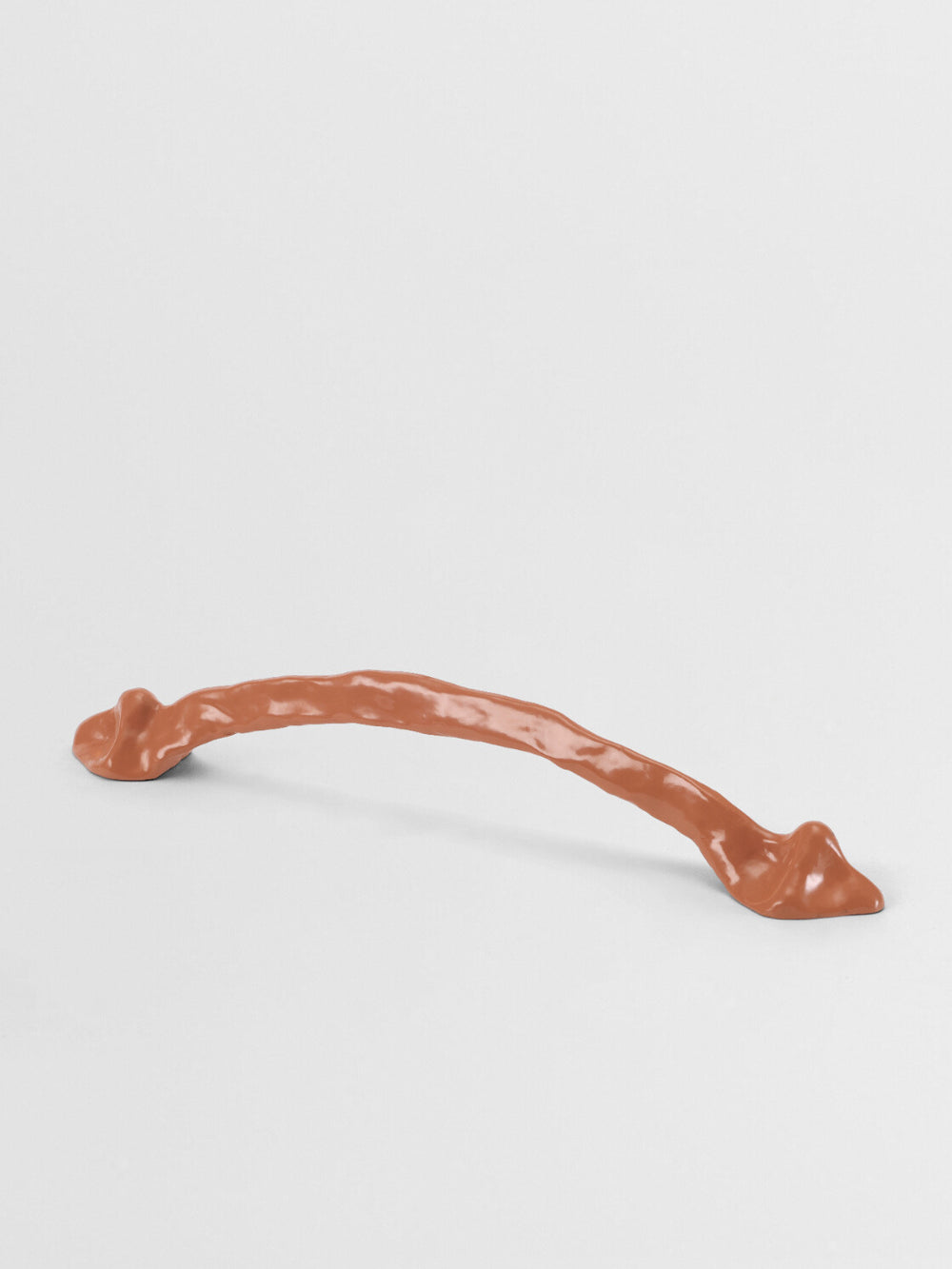 Orange cabinet handle organic on a light gray background