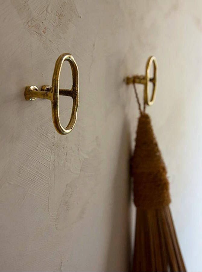Use of a natural brass colored towel wall hook