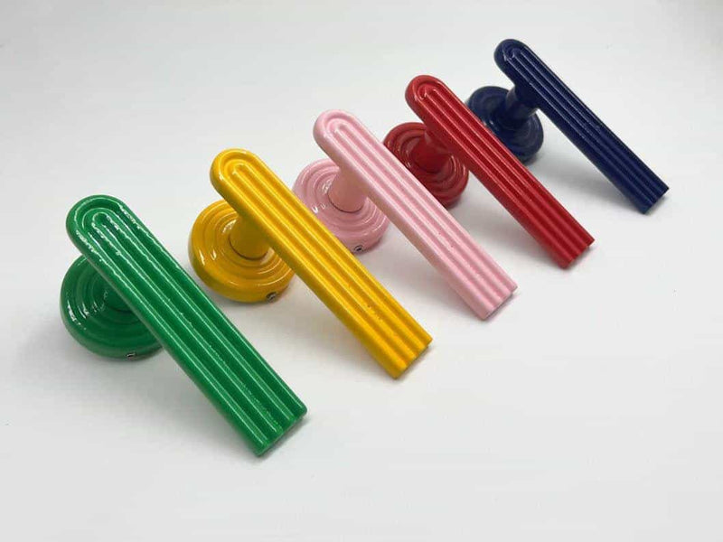 A left side view of five colored green, yellow, pink, red, and blue passage door levers sets