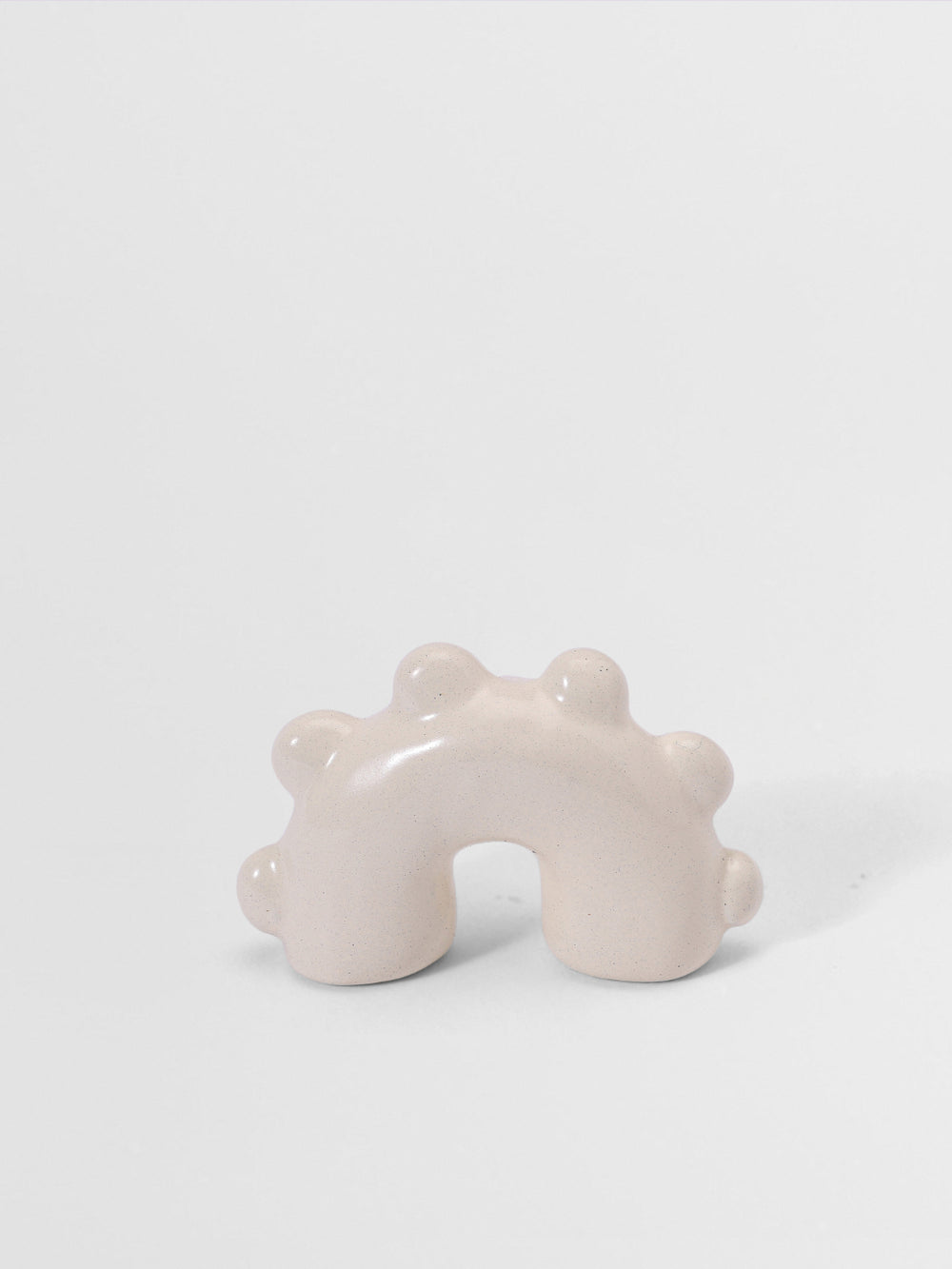 White arch sculpture pull knob on a light gray background