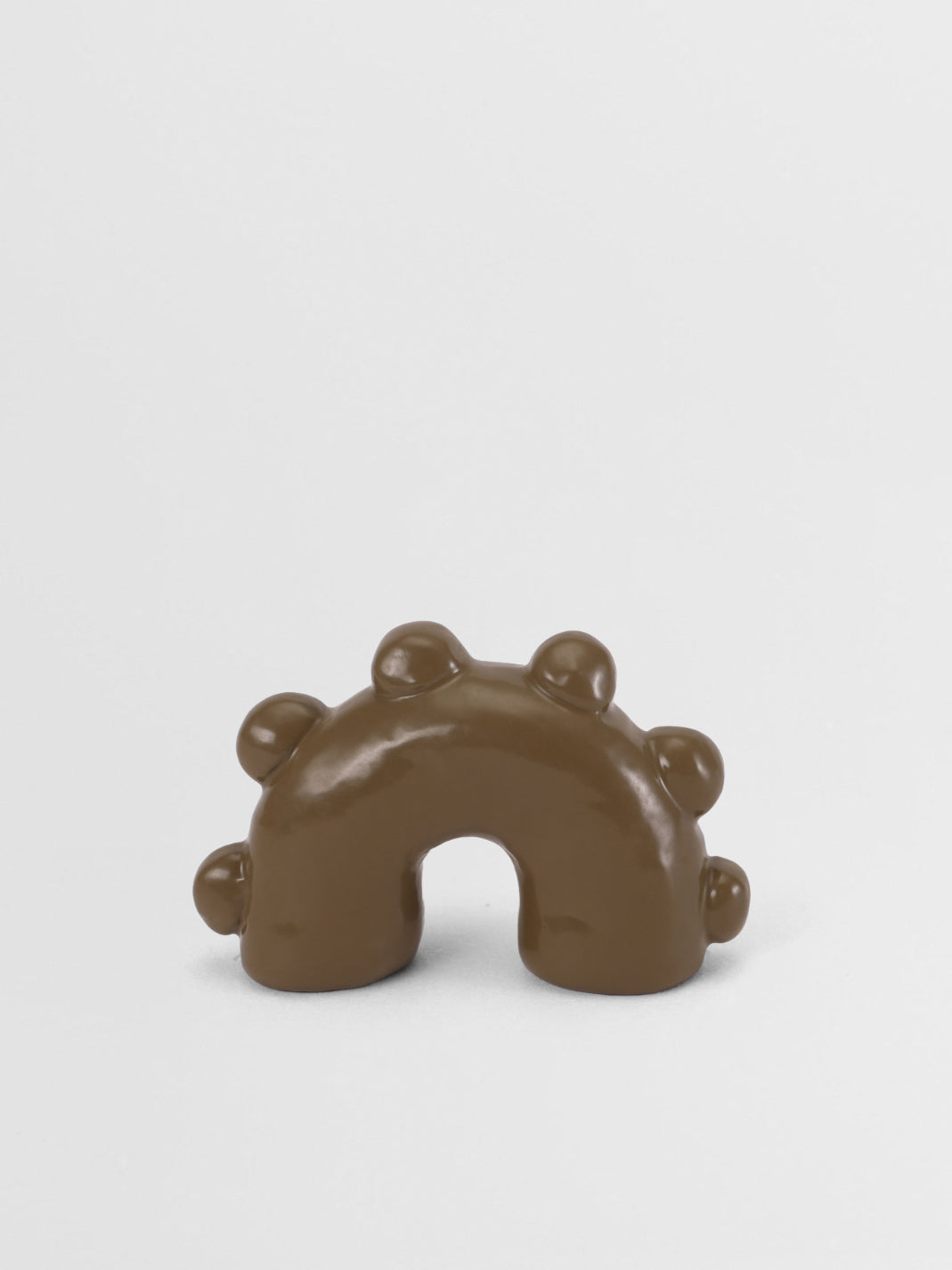Olive green arch-shape pull knob on a white background