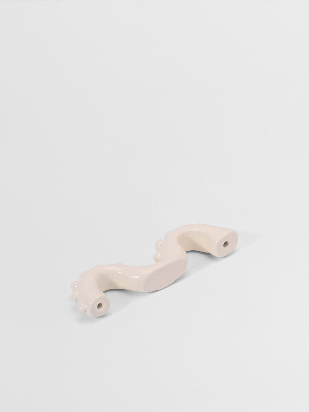 White organic shaped handle on a light gray background