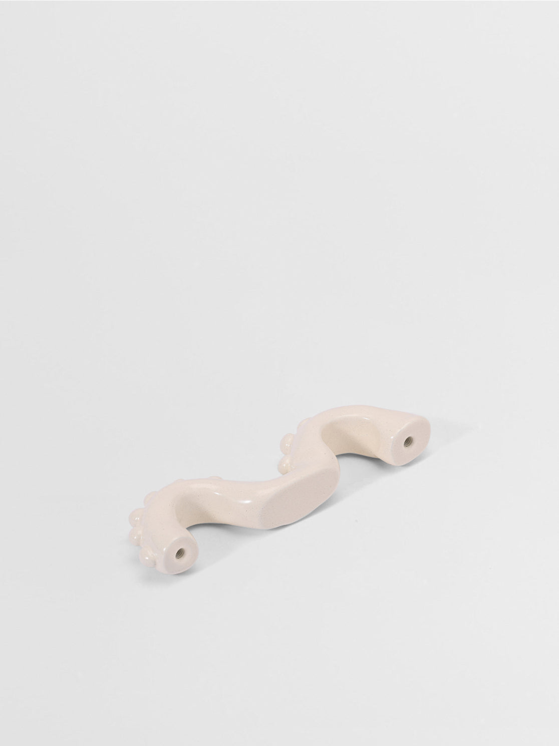White organic shaped handle on a light gray background