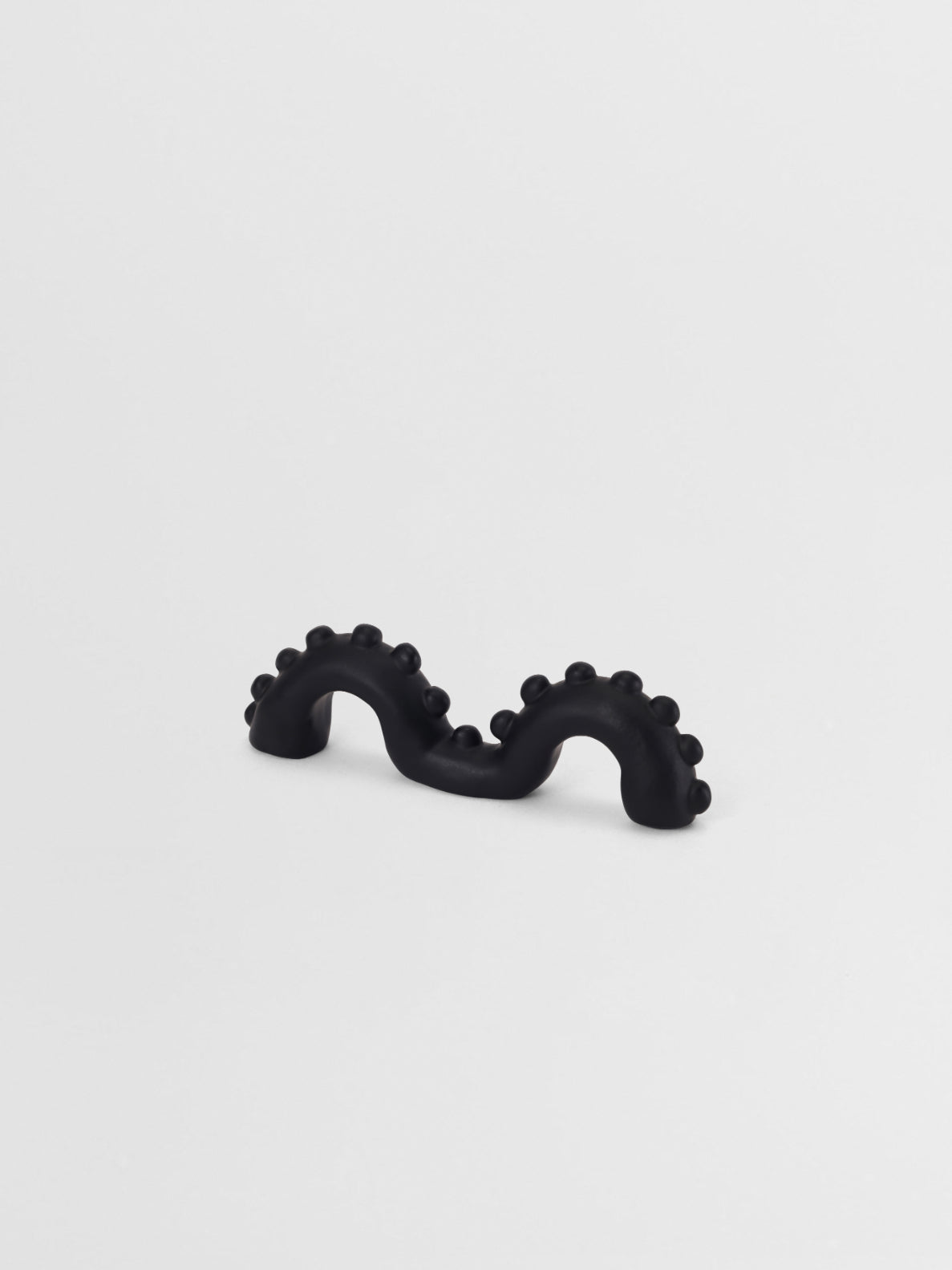 Black  organic shaped pull on a light gray background