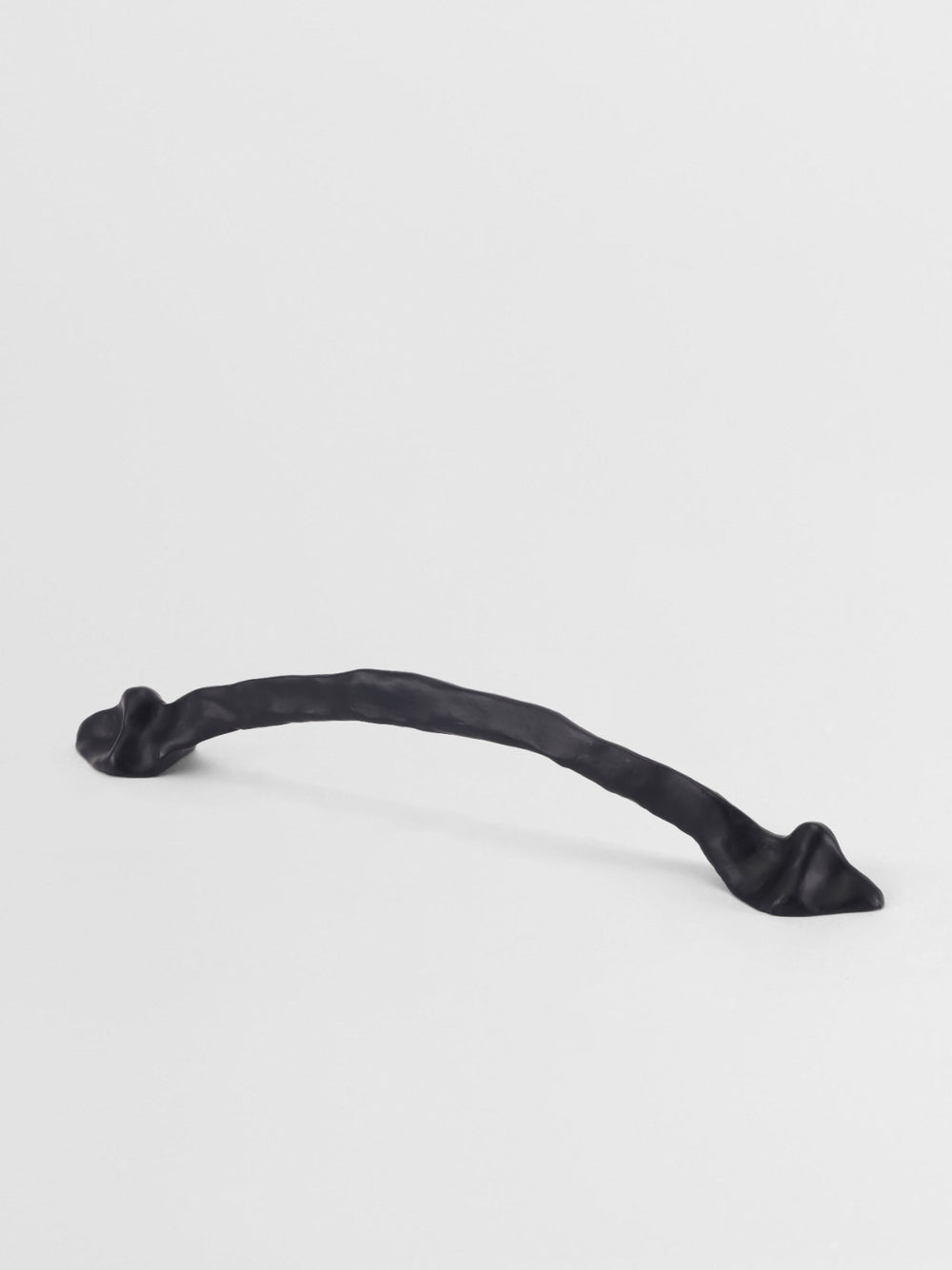 Black cabinet handle on a light gray background