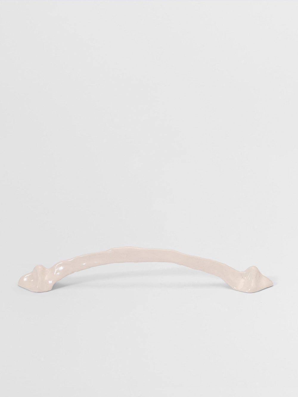 White organic cabinet handle on a light gray background