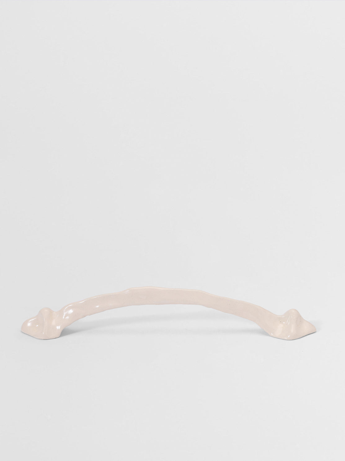 White organic cabinet handle on a light gray background