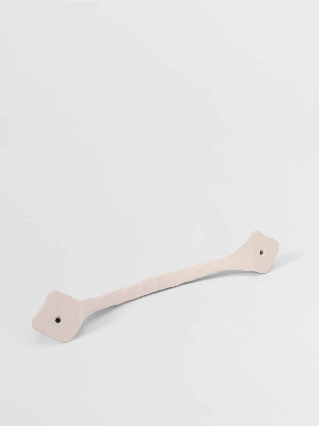 White organic cabinet handle on a light gray background