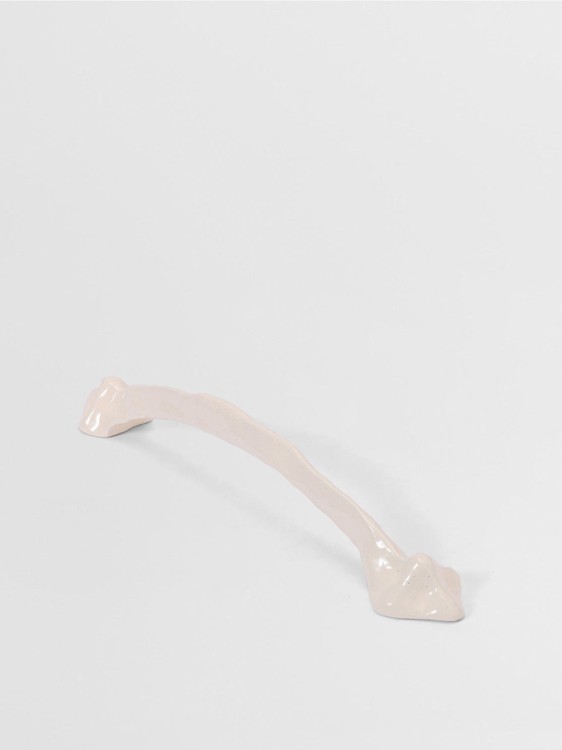 White organic cabinet handle on a light gray background