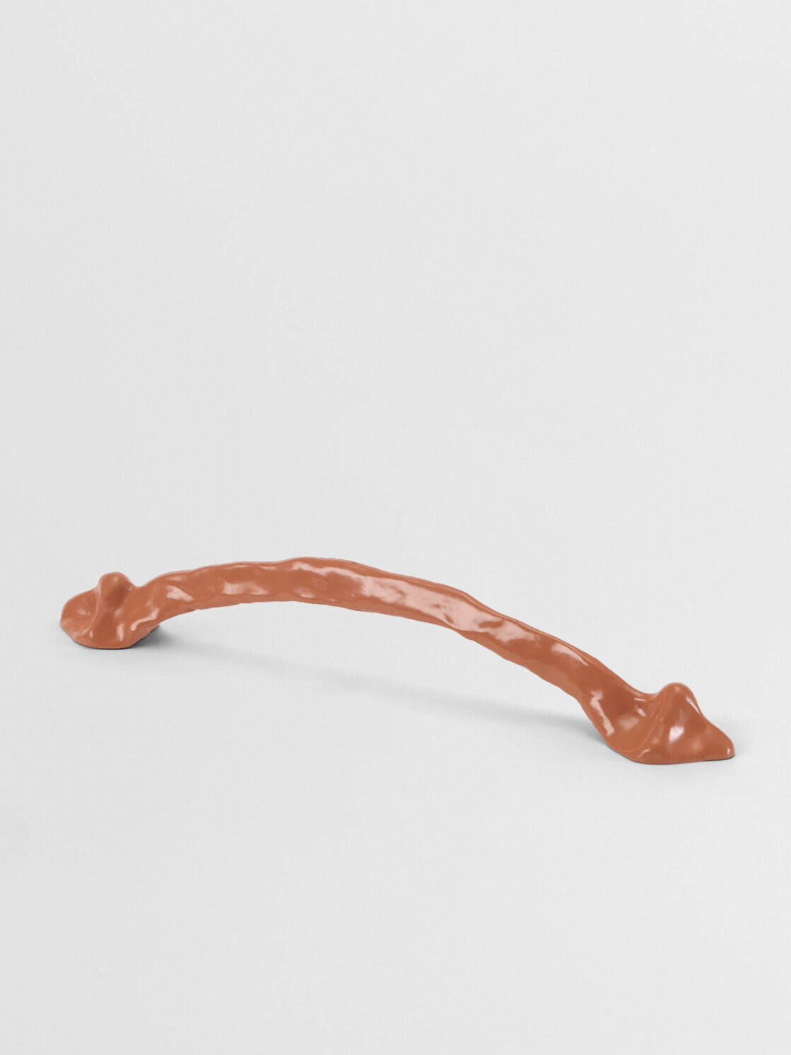 Orange cabinet handle organic on a light gray background
