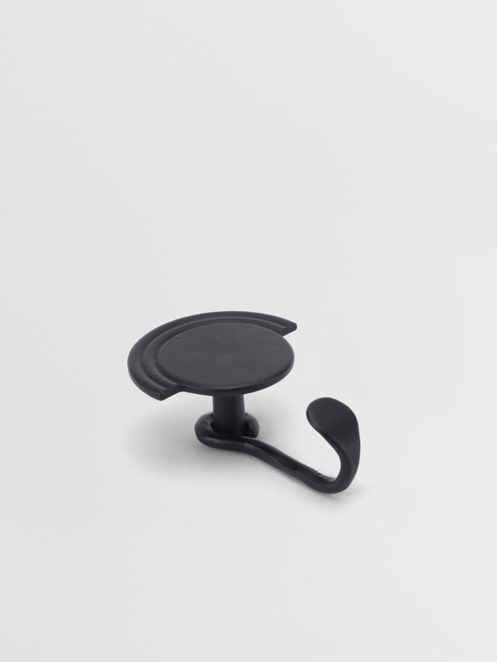 Black wall hook on a light gray background