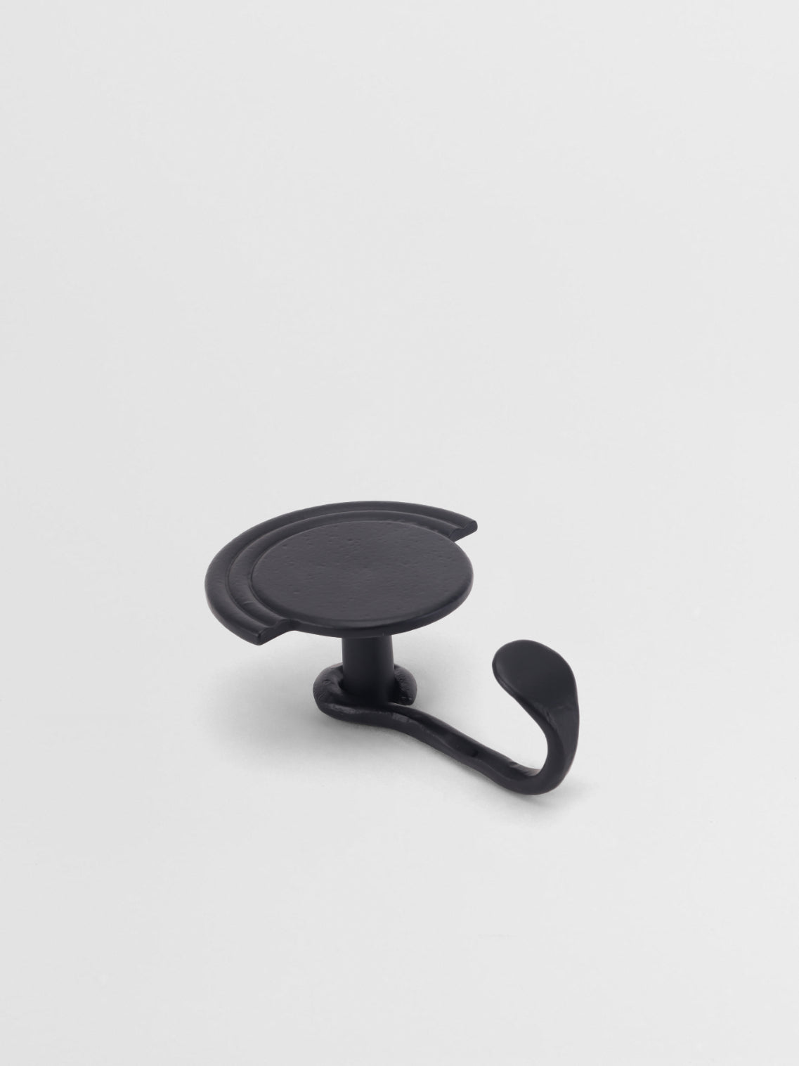 Black wall hook on a light gray background