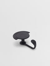 Black wall hook on a light gray background