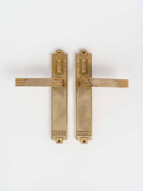 A left side and right view of a natural brass finish passage door lever set