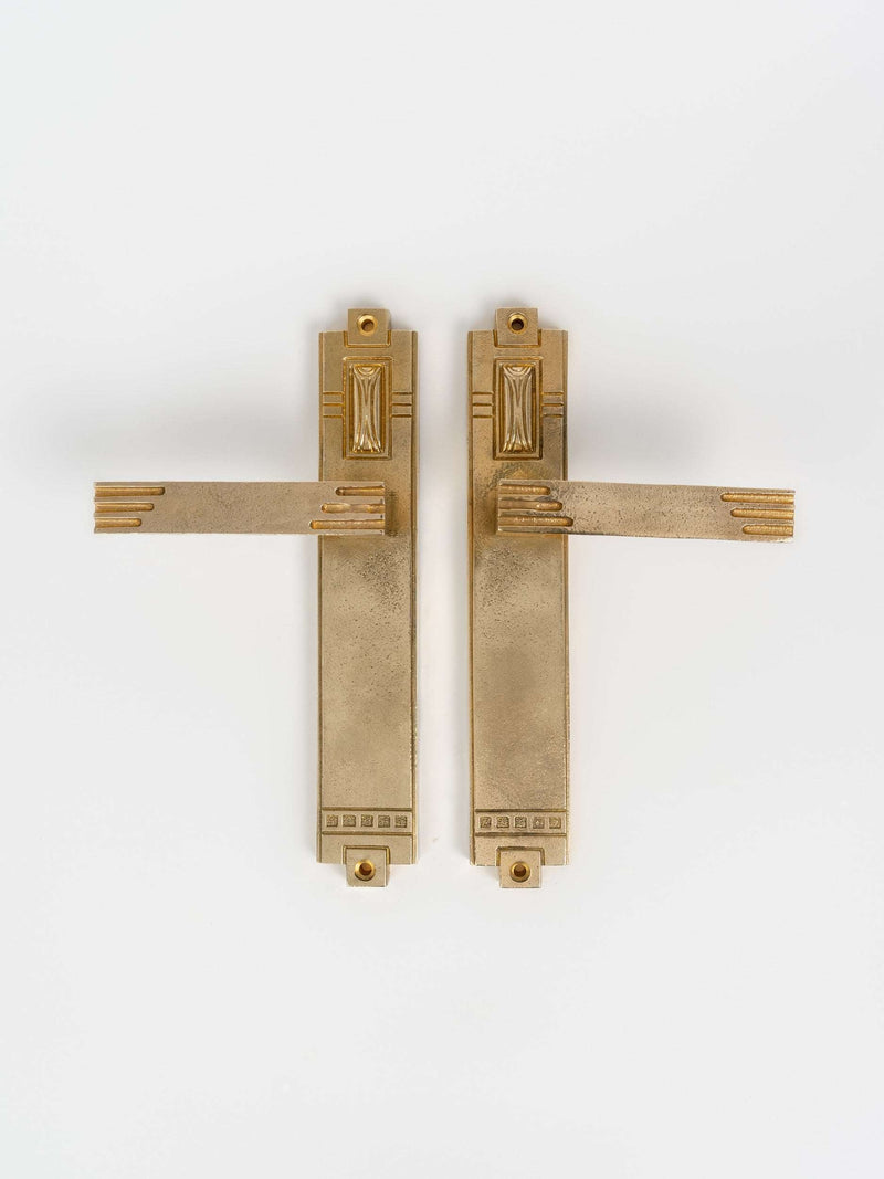 A left side and right view of a natural brass finish passage door lever set