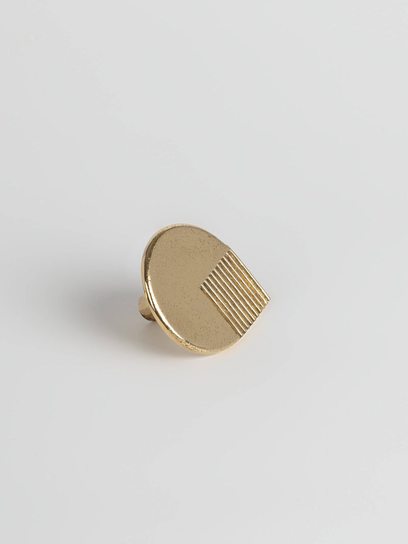  Left side view of a natural brass colored oversized door drawer pull