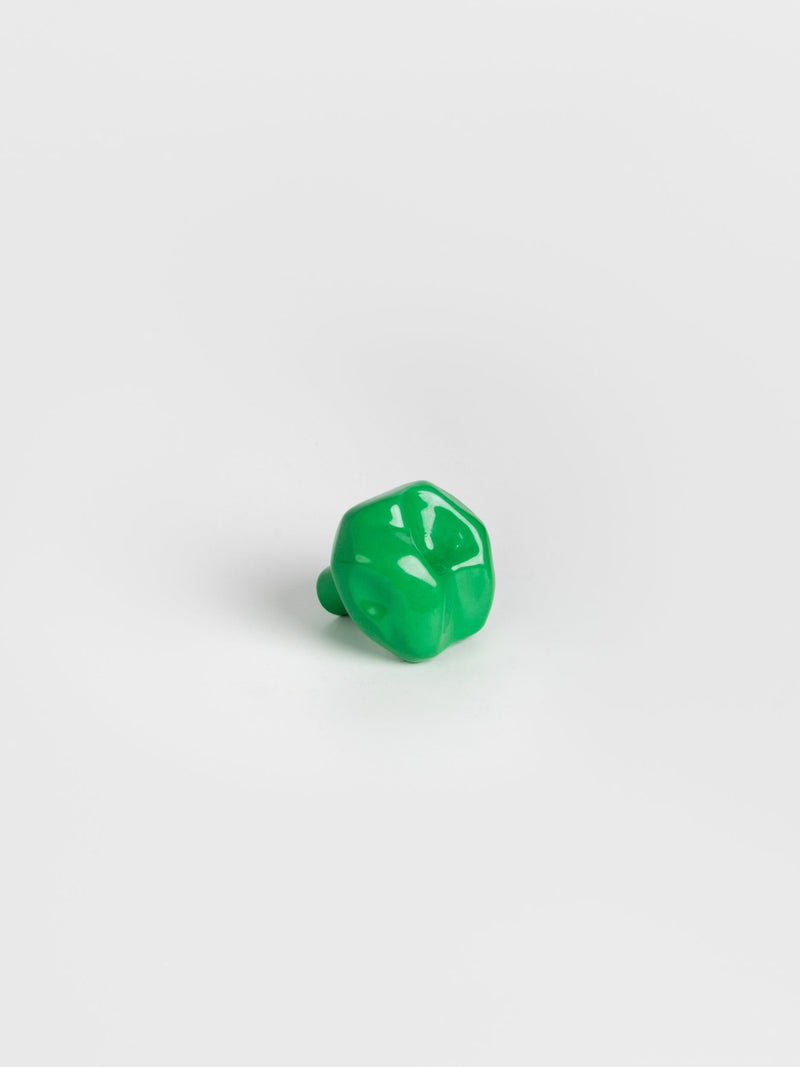  A left side view of a green colored wall hook 