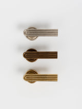 A top view of the three sets of brass, bronze, satin nickel passage door handle